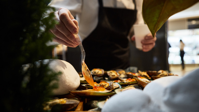 chef pouring sauce on plate