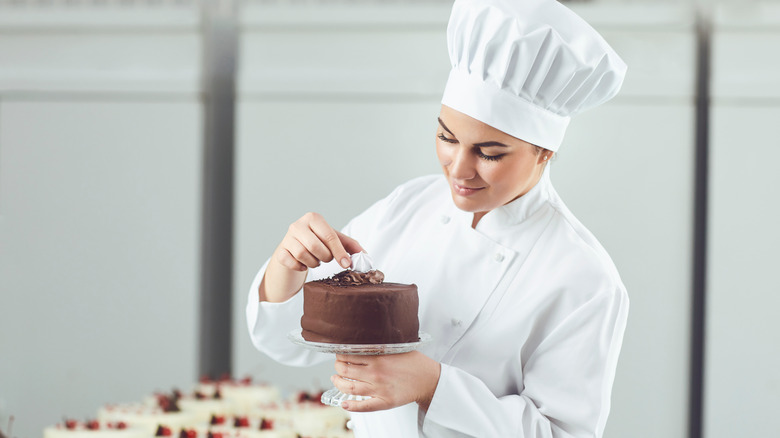 Pastry chef finishes chocolate cake