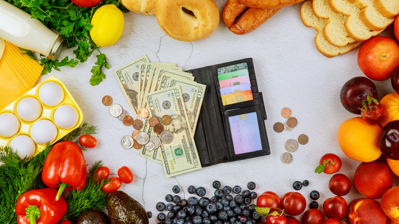 Wallet with cash surrounded by food