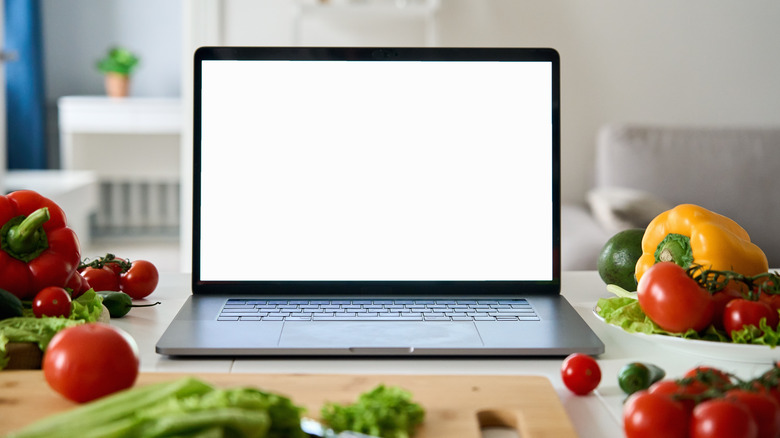 Computer screen surrounded by vegetables