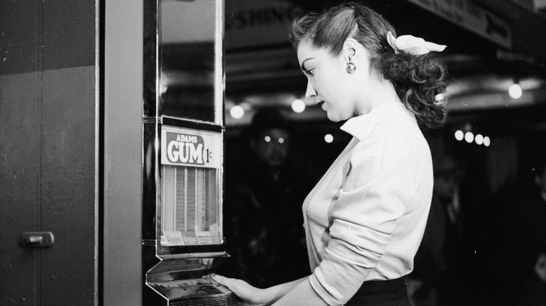 Woman buys gum from vending Machine, 1950