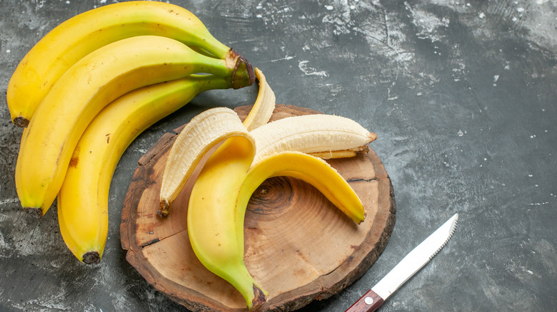 bananas on cutting board with knife