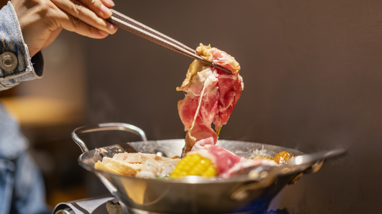 Dipping raw beef in hot pot