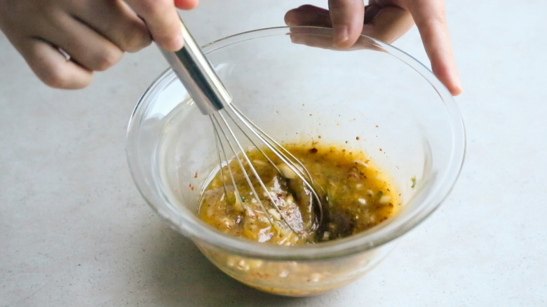 whisking chicken marinade in bowl