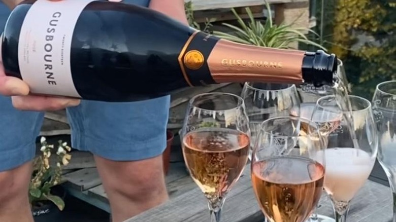 Man pouring Gusbourne rose into glasses