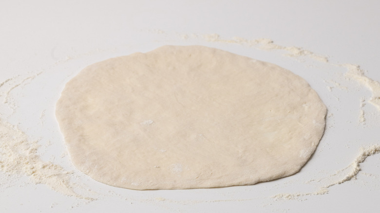 pizza base on floured surface