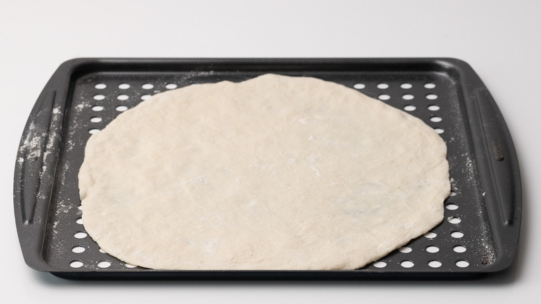 pizza base on baking sheet