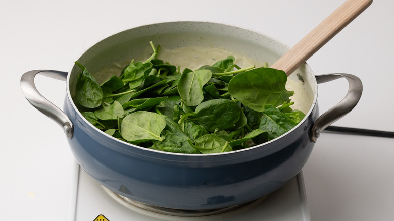 wilting spinach into pan