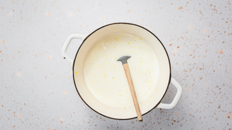 Milk base with lemon zest in pot