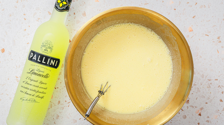 ice cream batter in bowl beside limoncello bottle