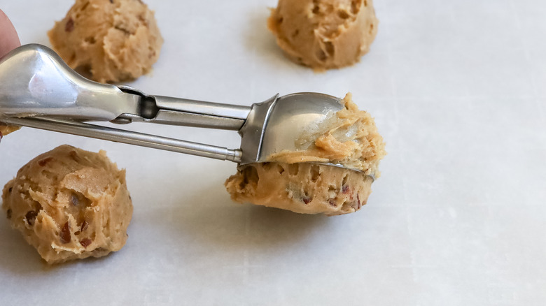 cookie dough being scooped onto a baking sheet