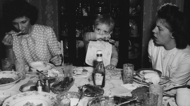 black-and-white photo, 1950, family eating dinner with ketchup