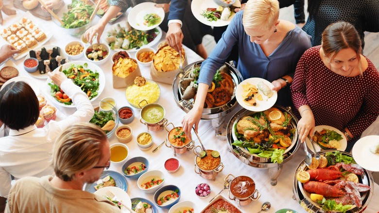 people helping themselves to a buffet table