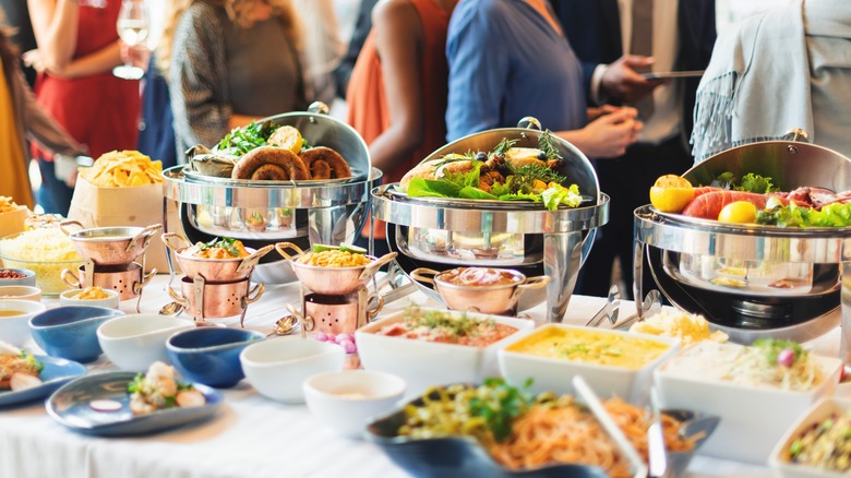 buffet items on table with people nearby