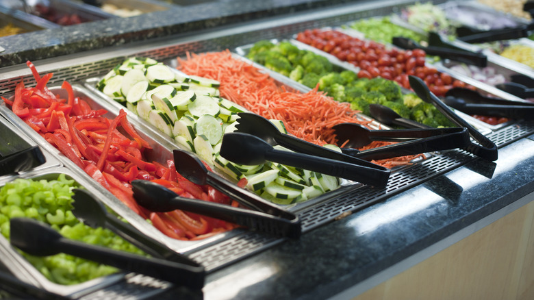 raw veggies on salad bar with tongs