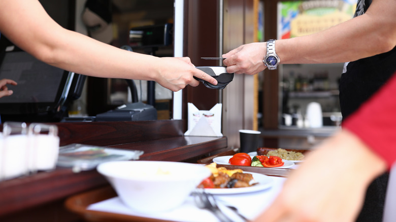 person paying with credit card for buffet food