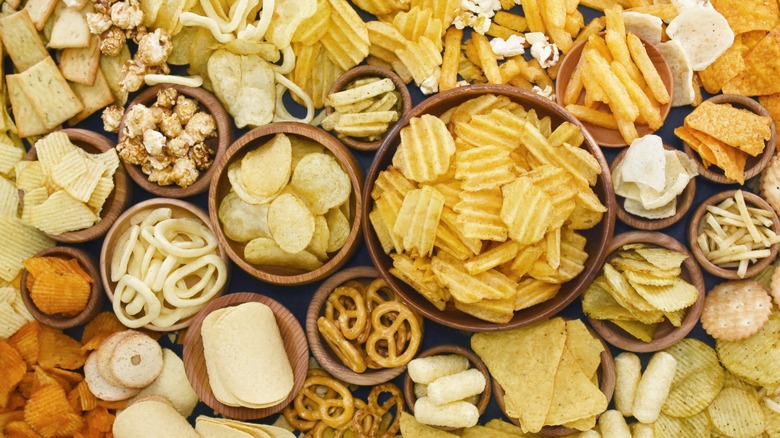 chips crackers pretzels popcorn laid out and organized in bowls