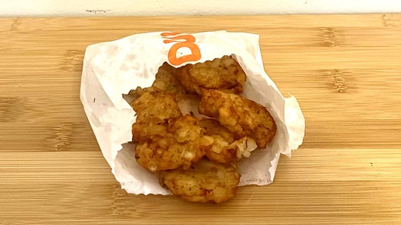 Dunkin' hash browns sit on a table.