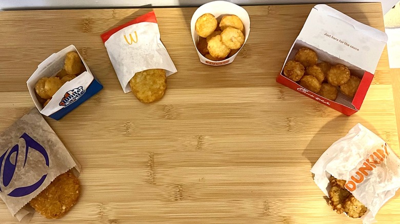 Fast food hash browns are lined up on a table.