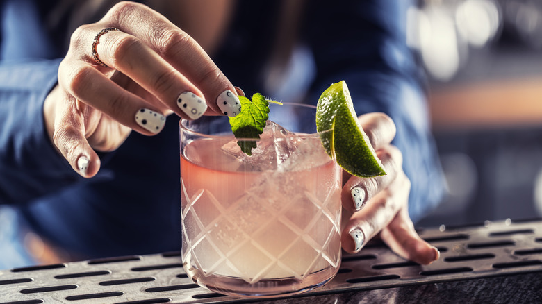 Bartender garnishing margarita