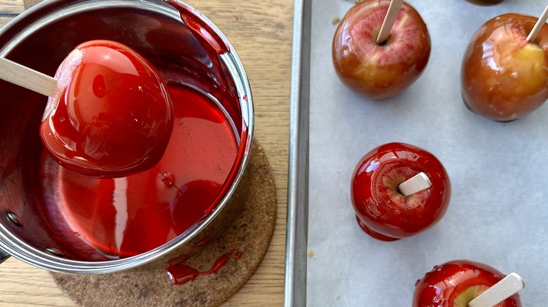 Dipping apples into candy coating