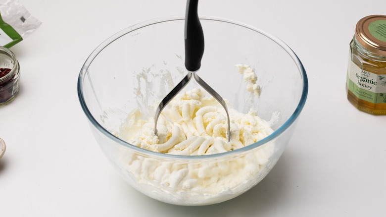 mashing cheeses in a bowl