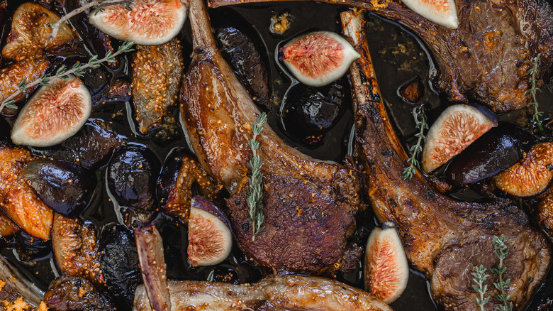 Close up on a pan of roasted lamb chops with thyme and figs