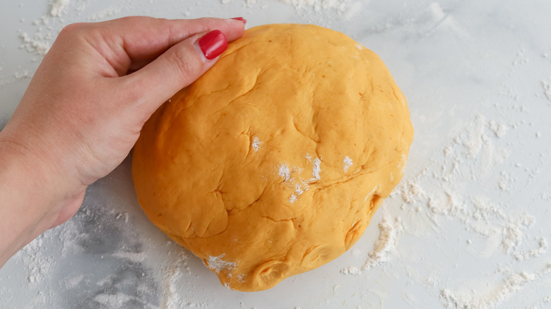 hand shaping dough into ball