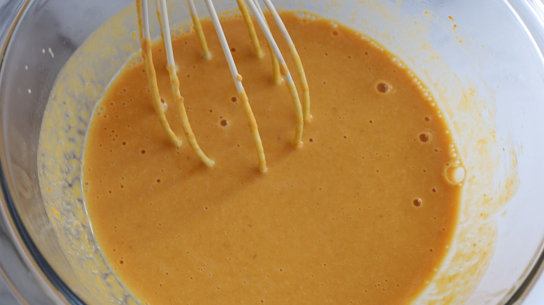 whisking pumpkin mixture in bowl