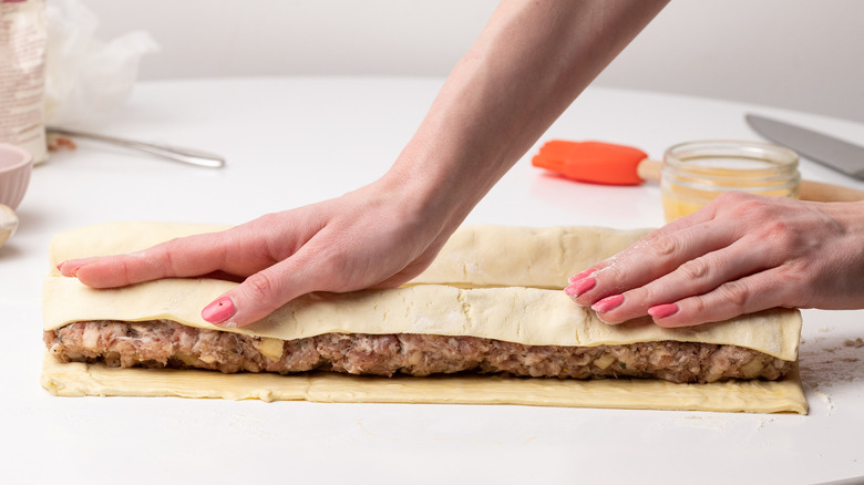 hands rolling sausage roll