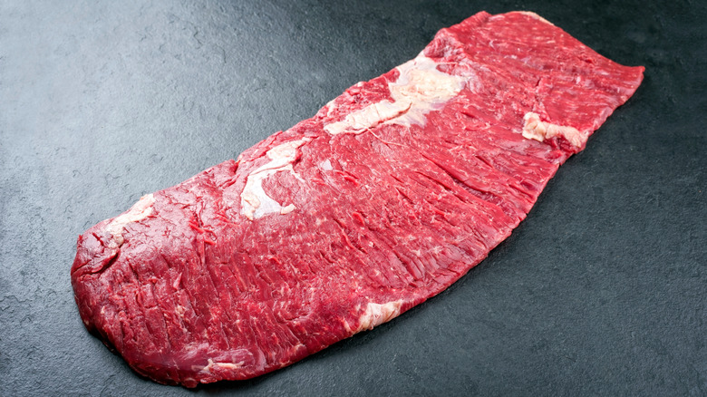 Raw bavette steak on black surface