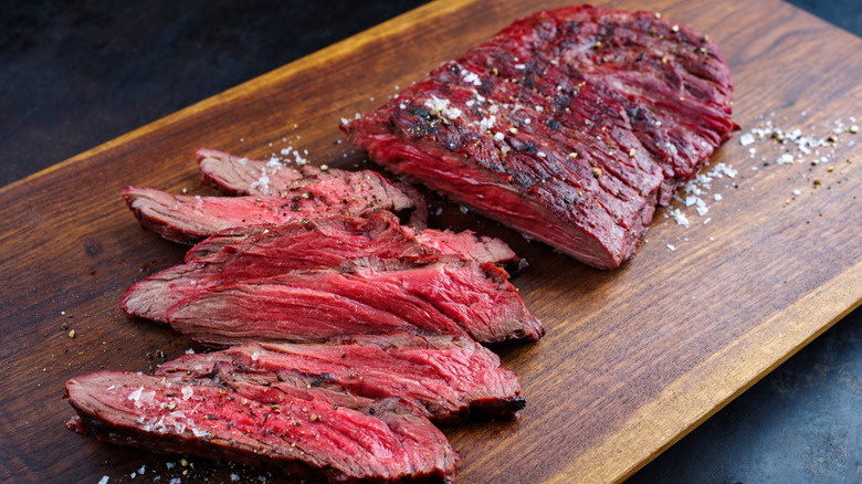 Sliced bavette steak on cutting board with salt and pepper