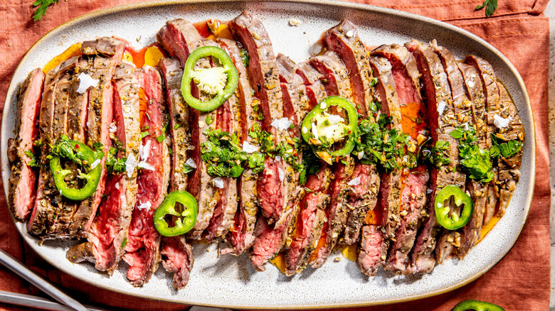 Plate of sliced grilled flank steak with peppers