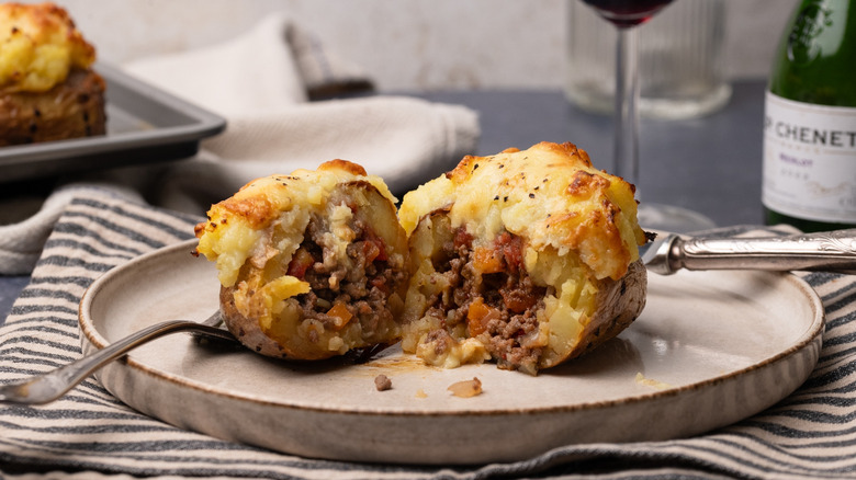 cottage pie baked potatoes on ceramic plate with silverware