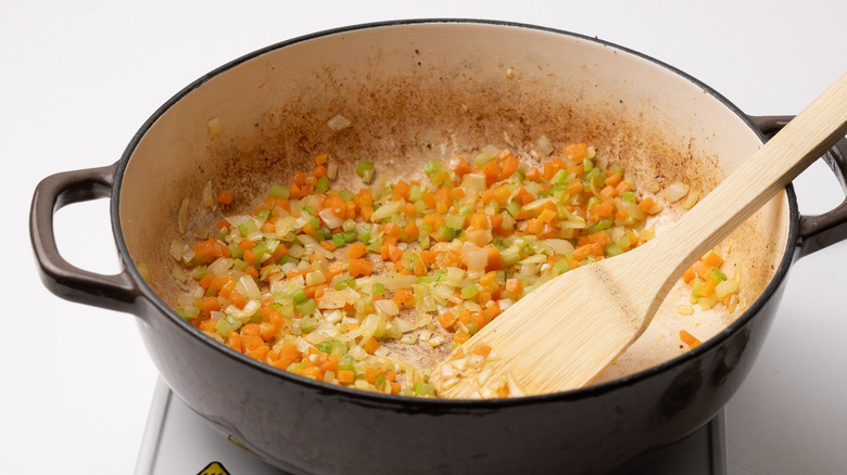 pan with sauteed mixed vegetables and wooden spatula