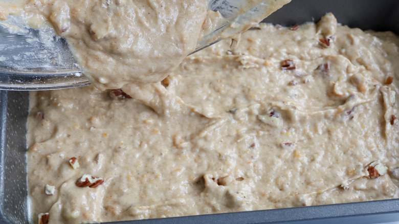 pouring banana bread batter into loaf pan