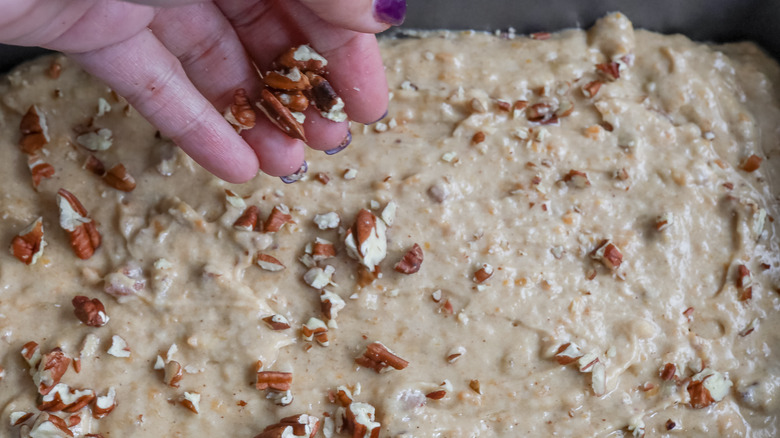 sprinkling pecans on batter