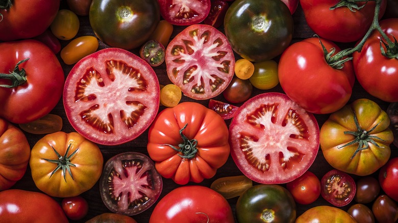 A mix of colorful whole and sliced tomatoes