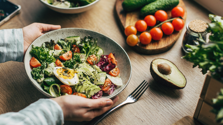 Person holding salad in bowl