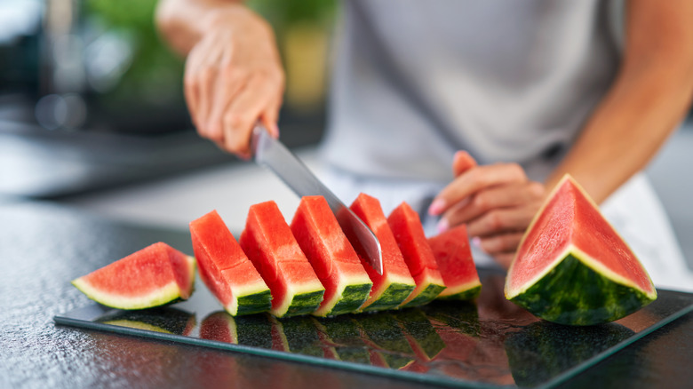 A person cutting a watermelon