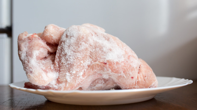 A frozen chicken on the kichen counter