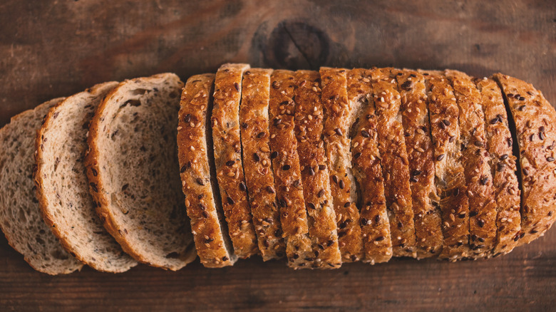 Wholegrain sliced bread on wooden background