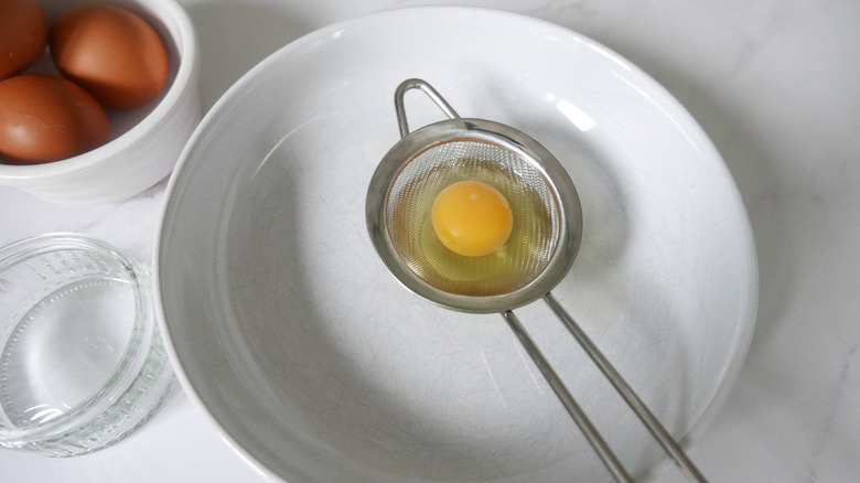 raw egg in strainer