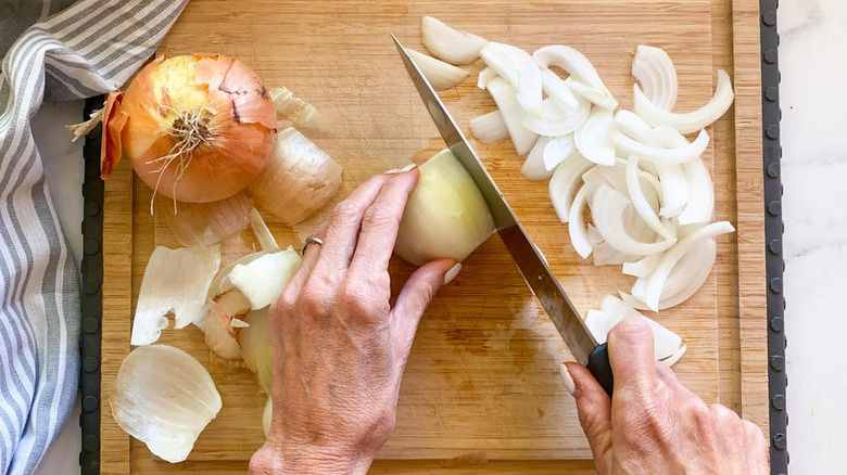 slicing onions on wooden board