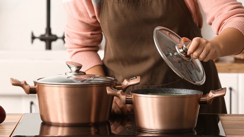 woman's hand lifting pot lid