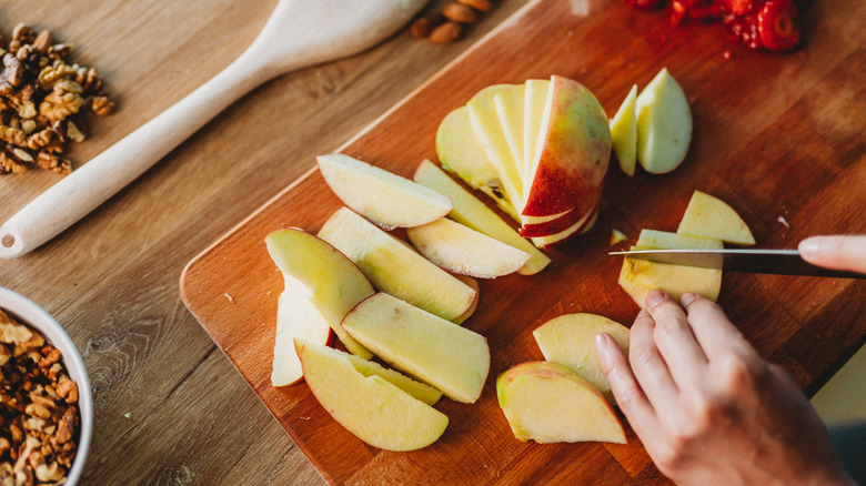 slicing apple on cutting board