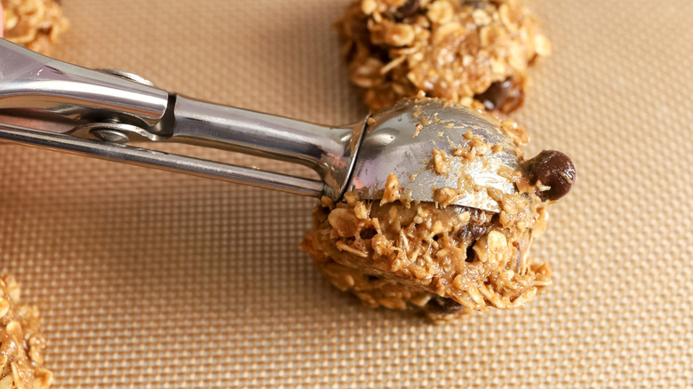 cookie batter being scooped onto baking sheets