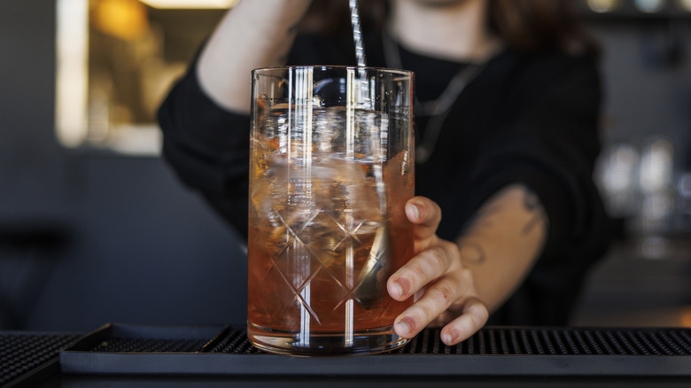 A bartender mixing Cognac in a glass