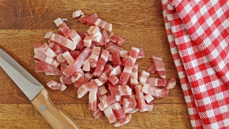 Bacon lardons on a wooden cutting board