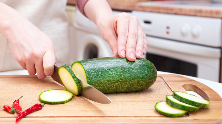 a woman slices a zucchini